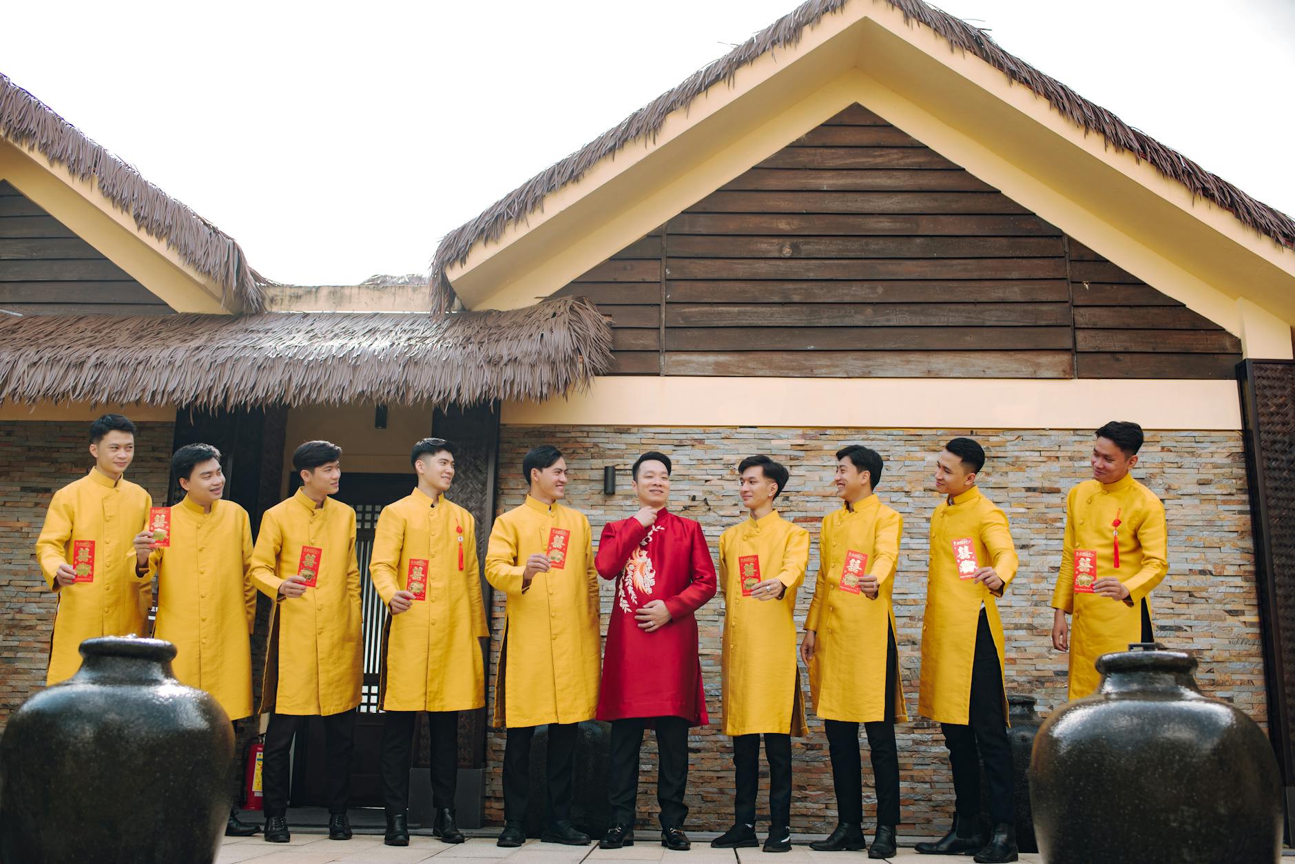 Pan młody i drużbowie w tradycyjnych strojach świętują na dworze