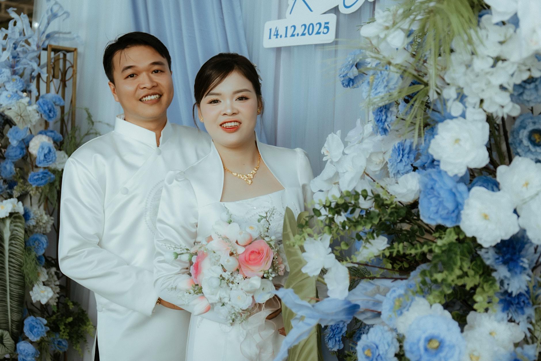 Para młoda w eleganckich strojach na tle biało-niebieskich kwiatów