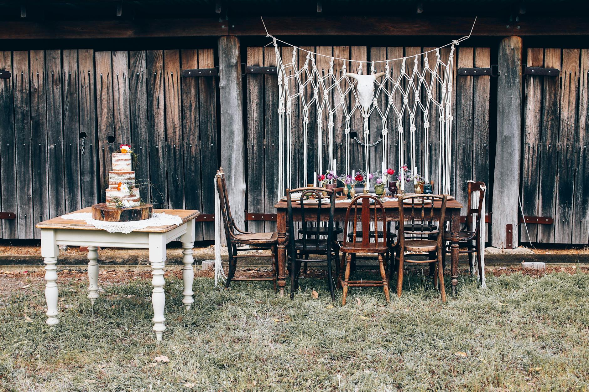 Rustykalna aranżacja boho na ślub w plenerze z naked cake i kwiatami