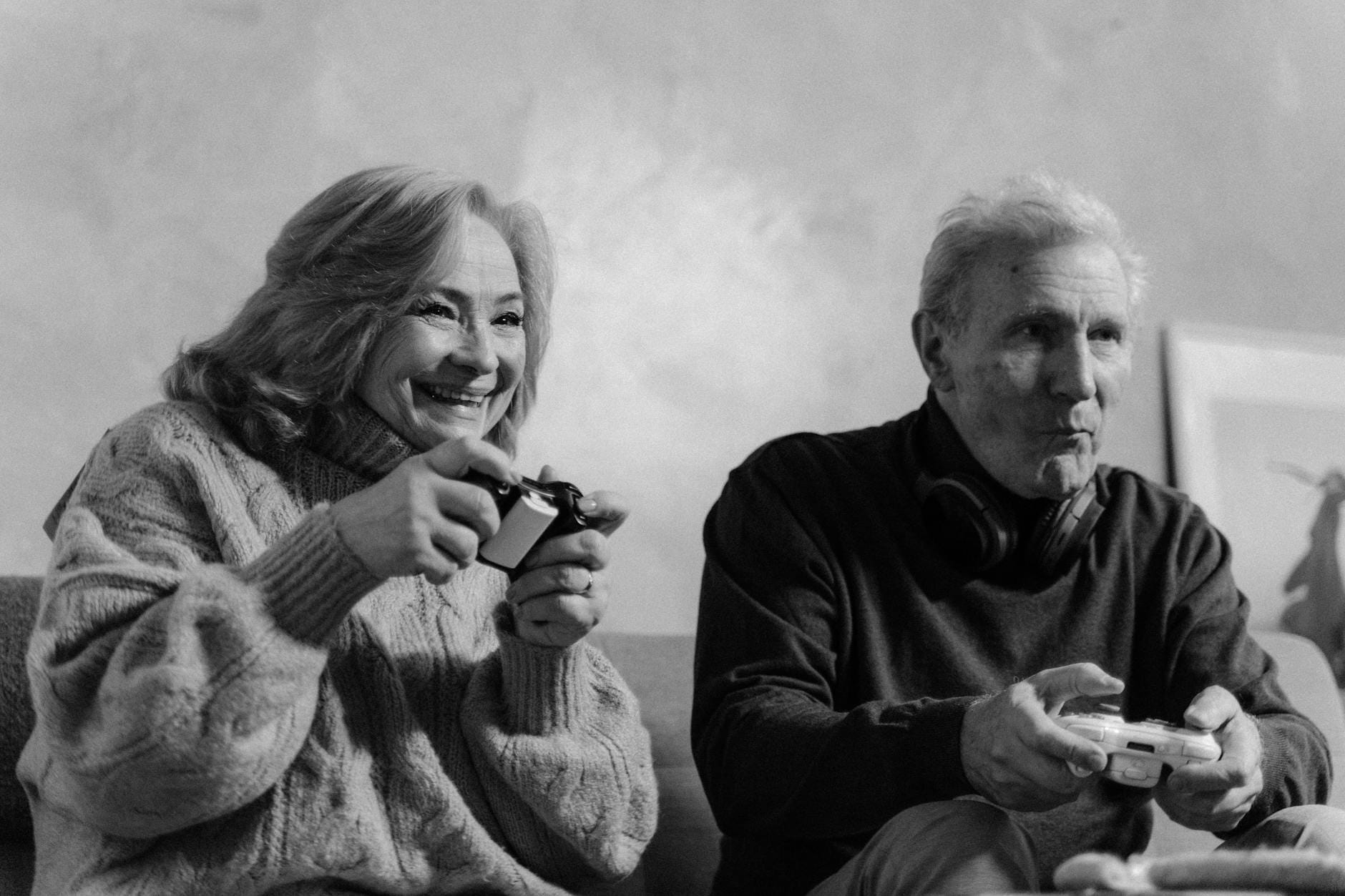 Starsze małżeństwo gra razem na konsoli w przytulnym salonie